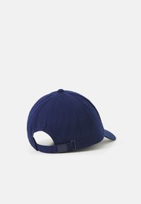 Caciulă de baseball de culoare bleumarin, făcută din bumbac, având o vizieră curbată, curea ajustabilă la spate și un detaliu mic de buton în vârf.