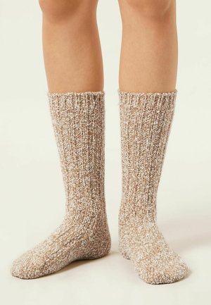 Chaussettes montantes en fil texturé marron et crème avec un motif côtes, dotées d'une finition tricotée confortable et d'un ajustement agréable.
