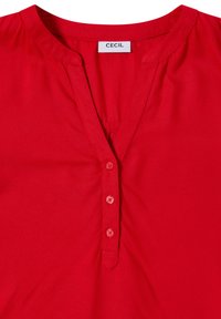 Blusa rossa con bottoni, realizzata in tessuto morbido, con scollo a V, maniche corte e cinque bottoni abbinati sul davanti. Etichetta del marchio: CECIL.