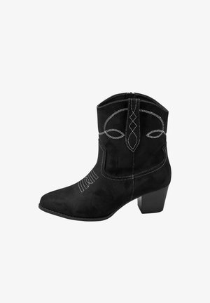 Bottine en suède noir avec un bout pointu et un talon bloc. Présente des motifs de coutures blanches décoratives et une fermeture éclair.