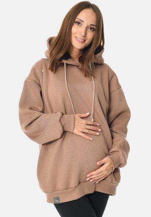 Übergroßer brauner Hoodie mit Kordelzügen, gerippten Bündchen und Saum, aus weichem Material gefertigt. Hat ein Etikett auf der unteren linken Seite.
