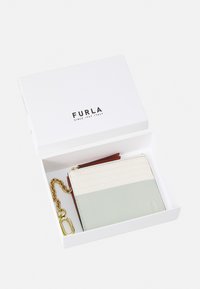 Furla-lommebok i en hvit boks, med en kombinasjon av strukturert kremfarge, mintgrønn og rød lær, samt gullkjede og hardware-detaljer.