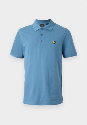 Polo en coton bleu clair avec une patte de boutonnage à trois boutons, des manches courtes, et un logo brodé jaune sur la poitrine.