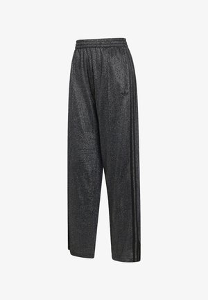 Pantalones de chándal anchos y brillantes de color negro con cinturilla elástica y tres franjas negras que bajan por los lados.