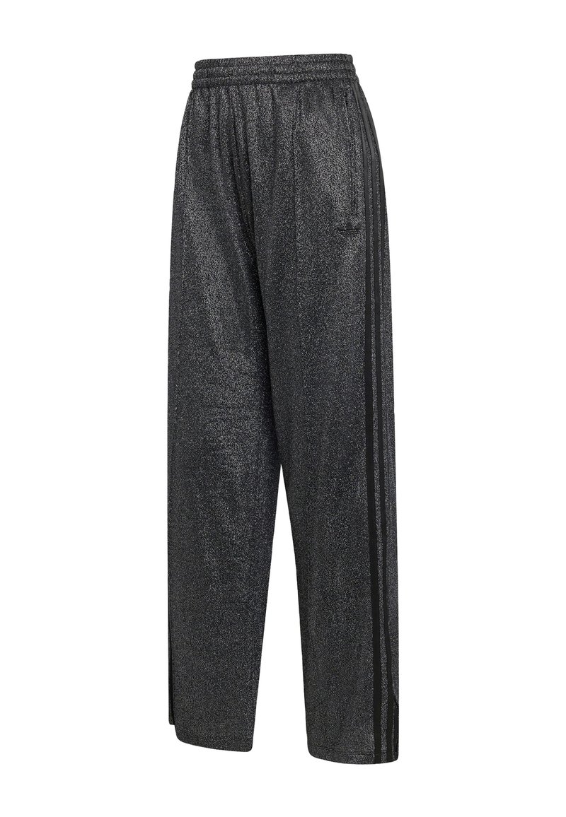 Pantalons de survêtement larges et brillants noirs avec une taille élastique et trois bandes noires sur les côtés.