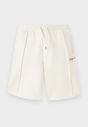 Cremefarbene Shorts aus weichem Material mit elastischem Taillenbund, Kordelzug, seitlichen Taschen und einem kleinen roten Logodetail an der Seite.