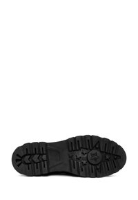 Semelle de chaussure en caoutchouc noir avec un motif de bande de roulement texturé, présentant des détails en étoile et en rayures, offrant adhérence et durabilité.