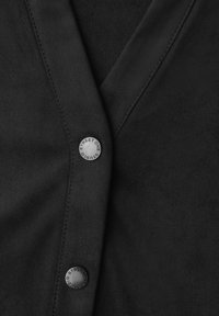 Schwarzer Wildlederstoff mit glatter Textur, mit V-Ausschnitt-Design und einer auffälligen Schaltfläche mit der Aufschrift "STREET ONE".