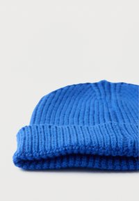 Μπλε πλεκτός σκούφος με ραβδωτή υφή και διπλωμένο περιθώριο. Το υλικό φαίνεται μαλακό και ζεστό, με ομοιόμορφη ραφή σε όλο το σχέδιο.