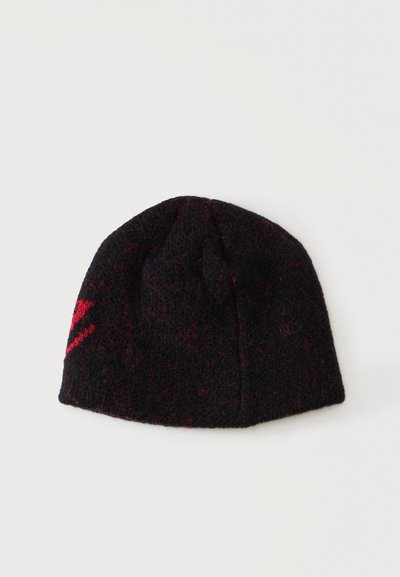 Μαύρος μάλλινος σκούφος beanie με διακριτικές κόκκινες κηλίδες και μικρό κόκκινο σχέδιο στη μία πλευρά, εμφανίζεται σε λευκό φόντο.