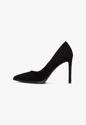Schwarzes Wildleder-High-Heel-Pump mit spitzem Zeh, glatter Textur und einem eleganten, minimalistischen Design; verfügt über einen dünnen Stiletto-Absatz.