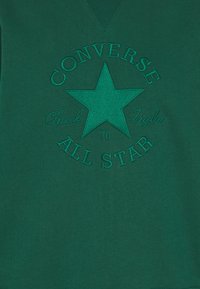 Felpa verde in cotone con un'icona ricamata a forma di stella e testo: "CONVERSE Chuck Taylor All Star 70" in filo verde abbinato.