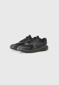 Schwarze Sportschuhe mit Obermaterial aus Mesh und synthetischem Material, strukturierten Akzenten, Schnürdesign und einem gemusterten Profil.