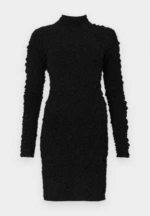 Rochie mini neagră cu mâneci lungi, texturată, cu gât înalt și siluetă mulată, pe un fundal simplu.