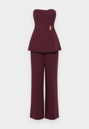 Bordó peplum felső pánt nélküli kivitelben, aszimmetrikus nyakkivágással és díszítő arany részlettel. Széles szárú nadrággal párosítva.