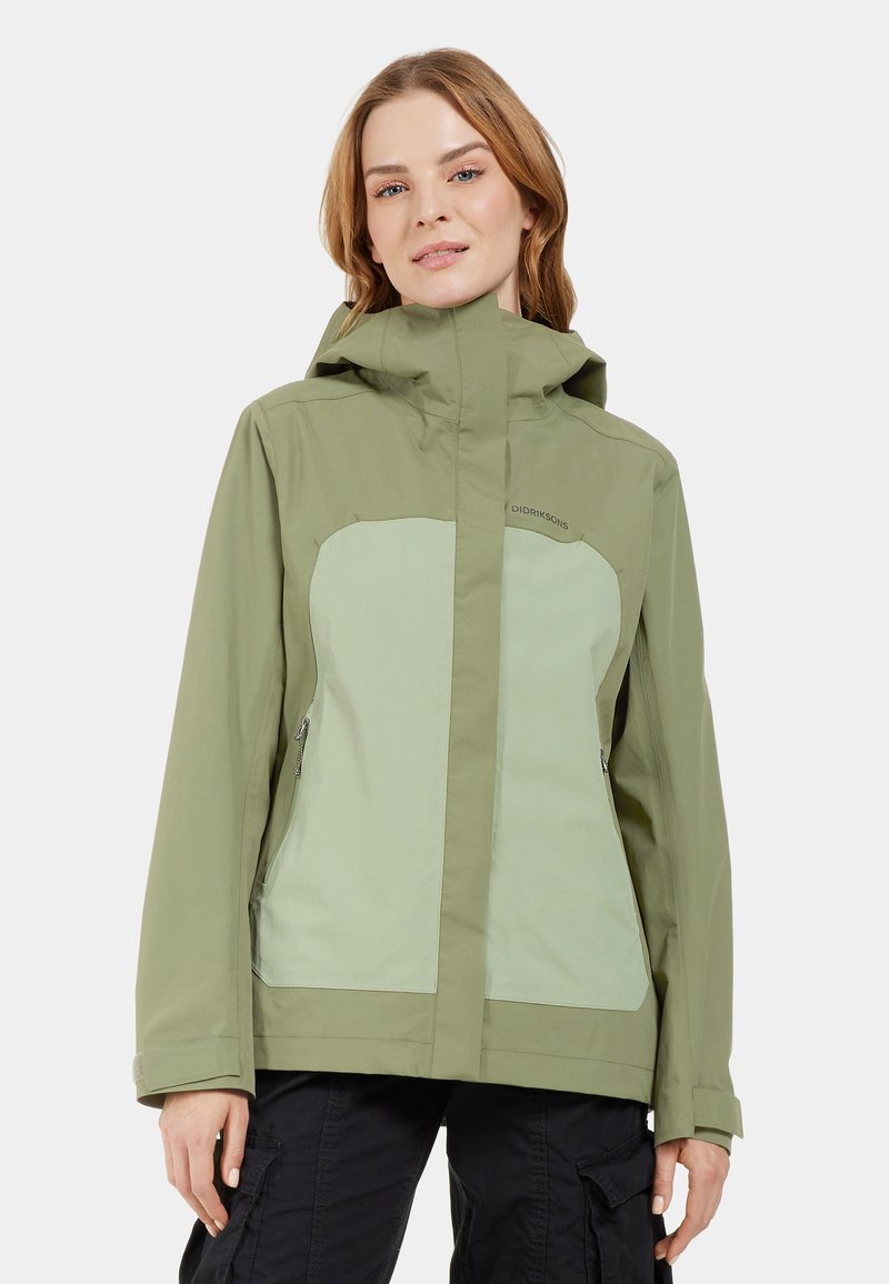 Veste imperméable verte avec un panneau vert plus clair, une capuche et des poches latérales zippées. Texture lisse, design pratique pour une utilisation en extérieur.