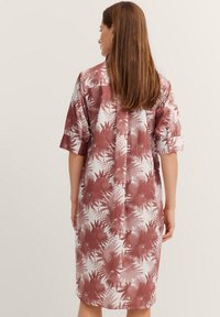 Knopfkleid aus leichter Stoffqualität, mit weißem Hintergrund und rotem tropischem Palmenblatt-Druck, dreiviertellange Ärmel und gerader Schnitt.
