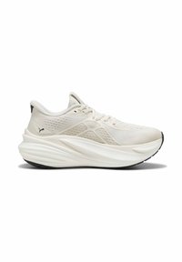 Baskets de sport blanches avec semelle épaisse et rembourrée, dessus en mesh, design à lacets, et logo Puma noir sur le côté du talon.