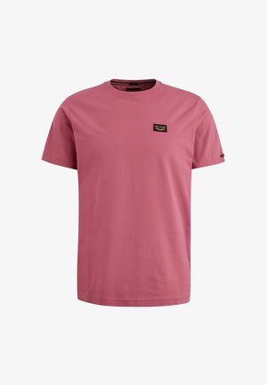 Lyserød bomulds t-shirt med rund halsudskæring og korte ærmer. Har en lille sort logo patch foran. Glat tekstur.