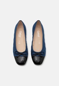 Paire de ballerines bleu marine avec bouts en cuir verni noir et petits nœuds, taille 4,5, marque Gabor visible à l'intérieur.