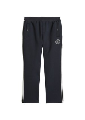 Pantalon de survêtement noir avec bandes blanches sur les côtés, taille élastique, deux poches avant à boutons-pression, et un logo circulaire MOP sur la cuisse droite.
