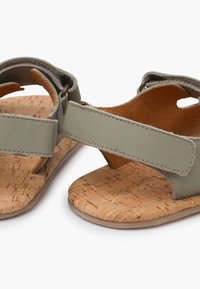 Šedé kožené sandály s korkovou stélkou. Obsahují nastavitelné popruhy a výřezy pro prodyšnost. Plná podešev s minimálním texturou.