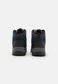 Un par de botas de senderismo en azul marino y negro mostradas desde la parte trasera sobre un fondo blanco liso, con tiradores y suelas resistentes.