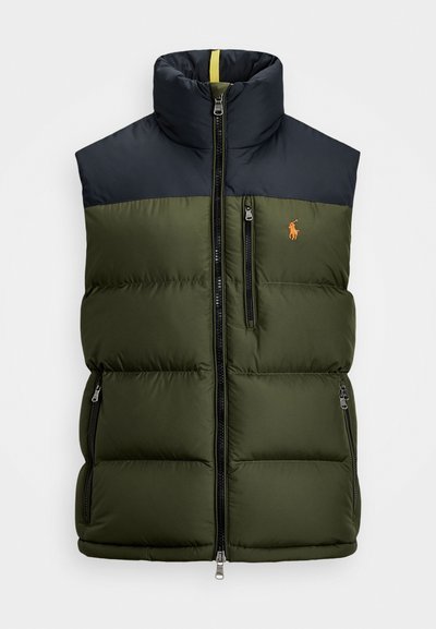 Grön pufferväst med marinblå axlar, hög krage, två framfickor med dragkedja och en liten orange logotyp. Har vadderad struktur och dragkedjor.