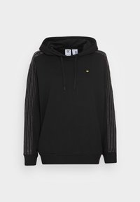 Černá mikina s kapucí a žebrovanými manžetami, s třemi bílými svislými pruhy na každém rukávu a malým zlatým logem na hrudi.