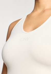 Λευκή αμάνικη μπλούζα με στρογγυλή λαιμόκοψη και μαλακή υφή. Δίσκος "ICIW" εκτυπωμένος μπροστά. Σχεδιασμένη για άνεση και εφαρμογή.