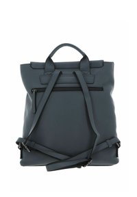 Sac à dos en cuir synthétique gris avec doubles poignées supérieures, bretelles réglables et une poche avant zippée. Texture lisse, design minimaliste.