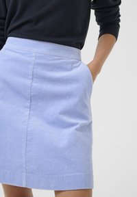 Ljusblå kordflodds kjol med slim fit, med midjeband och sidofickor, texturerad med smala vertikala ribbor.