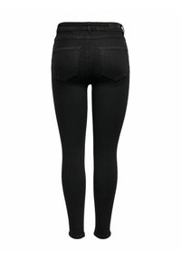 Črne visokotršne skinny jeans hlače z dvema zadnjima žepoma in zankami za pas, prikazane s hrbtne strani na beli podlagi.