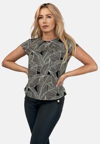 Czarny top z krótkimi rękawami w biały liściasty wzór, z okrągłym dekoltem i nieznacznym peplum. Połączony z czarnymi spodniami z złotymi guzikami.