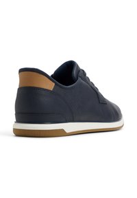 Navy leather sneaker with a tan accent at the heel, white midsole, and textured surface. Features lace-up closure and rubber outsole.