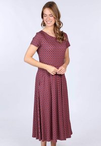 Kurzärmliges, mittellanges Kleid in Dunkelrosa mit geometrischem Muster, aus einem dehnbaren Stoff gefertigt. Es hat einen runden Ausschnitt und einen ausladenden Rock.
