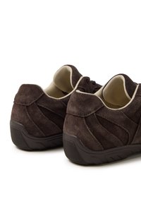 Scarpe in suede marrone con una forma arrotondata e un design testurizzato. Presentano accenti di colore chiaro e interni imbottiti per il comfort.