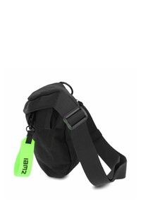 Bolso de hombro de tela negra con correa ajustable, que presenta un tirador de cremallera de color verde brillante. Forma compacta con una textura suave y diseño minimalista.