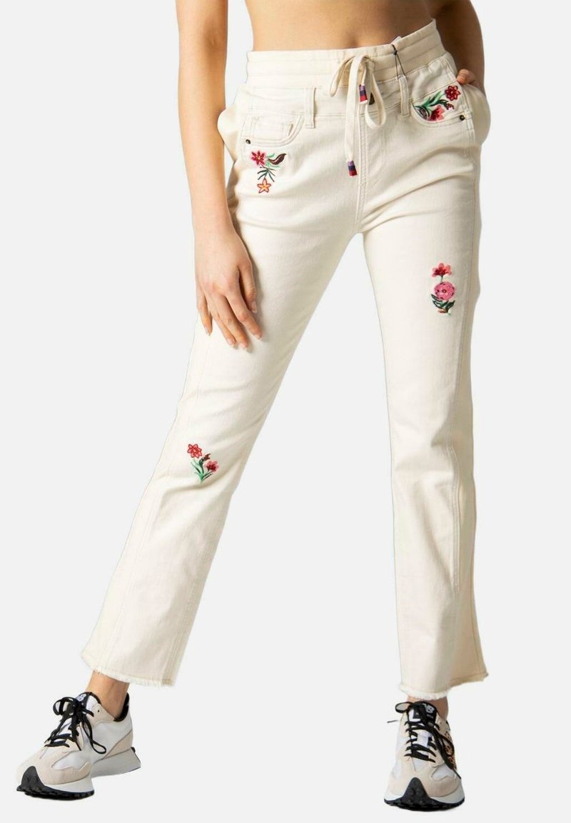 Witte denim broek met bloem borduurwerk op de zakken en benen, met een recht model en een trekkoord in de taille. Gecombineerd met sportieve schoenen.