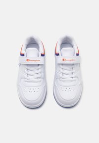 Sneakers bianchi con tomaia sintetica liscia, dettagli blu e arancioni, chiusura con lacci e strap in velcro, e dettaglio di punta perforata.