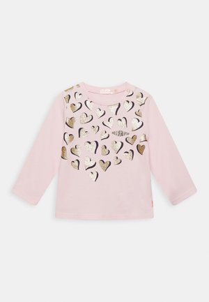 Lichtroze lange mouwen peutershirt met meerdere metalen gouden en zilveren hartvormen verspreid over de voorkant.