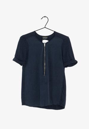 Blusa navy a maniche corte con scollatura tonda e dettaglio con zip frontale. Realizzata in un tessuto morbido con polsini a manica arrotolati.
