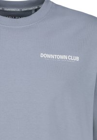 Himmelblauer Pullover aus weichem Stoff. Verfügt über einen runden Ausschnitt und bedruckten weißen Text mit der Aufschrift "DOWNTOWN CLUB" auf der Brust.