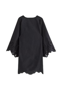 Svart klänning med bollärmar, som har utskurna spetsdetaljer vid ärmkanterna och en scallopad nederkant. Slät tygtextur.