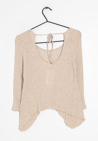 Beige, geripptes Langarmoberteil mit weitem Ausschnitt, Bindeband-Rückendetail und geschwungenem, unregelmäßigem Saum. Hergestellt aus einem weichen Stoff mit strukturierter Oberfläche.