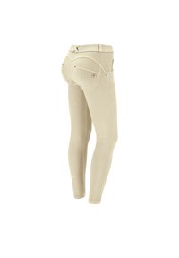 Leggings beige realizzati in tessuto elastico, con un design aderente, due tasche posteriori e dettagli di cucitura sottili.