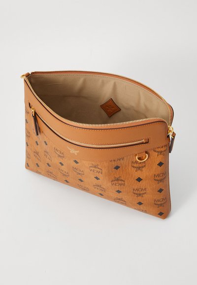 Pochette en cuir marron avec quincaillerie dorée, présentant un motif de logo en relief et une fermeture éclair. Intérieur doublé en tissu léger, comprend une poche plaquée.
