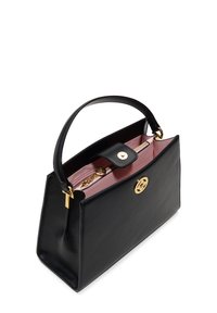 Sac à main en cuir noir au design structuré, avec un intérieur rose, un logo doré et un accent en chaîne détachable sur la fermeture éclair.