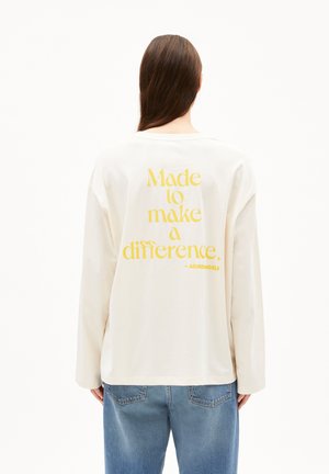 Long-sleeve off-white t-shirt made of cotton, featuring yellow text on the back: "Made to make a difference." Crew neck and relaxed fit.