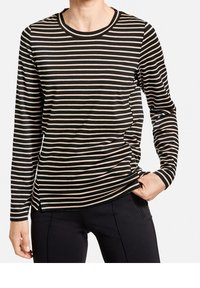 Svart och beige randig långärmad skjorta med rund halsringning och sidofickor. Mjuk tyg med avslappnad passform, bärs med mörka byxor.